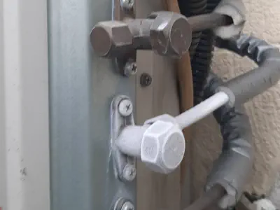 Dettaglio ravvicinato delle valvole del compressore con ghiaccio/brina: possibile perdita di gas refrigerante o guasto.