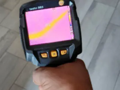 Tecnico con termocamera cerca una piccola perdita nellìimpianto di riscaldamento a Pesaro-Urbino.